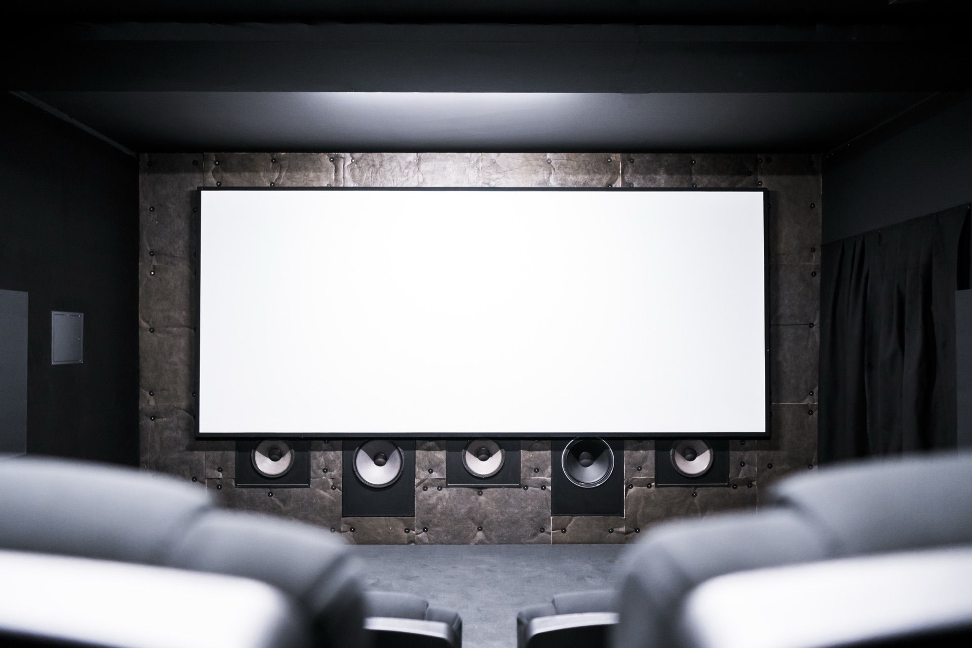 Blick über die Sessellehnen auf die fünf Meter breite Leinwand des Stardust Kinos